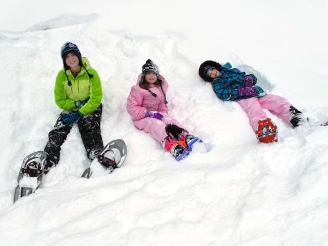 Trois enfants dans la neige en colonie de vacances cet hiver