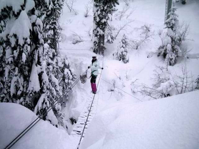 adolescente faisant de la via ferrata des neiges en colonie de vacances 