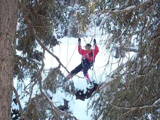 jeune ado faisant de l'accrobranche à la neige cet hiver en colonie de vacances