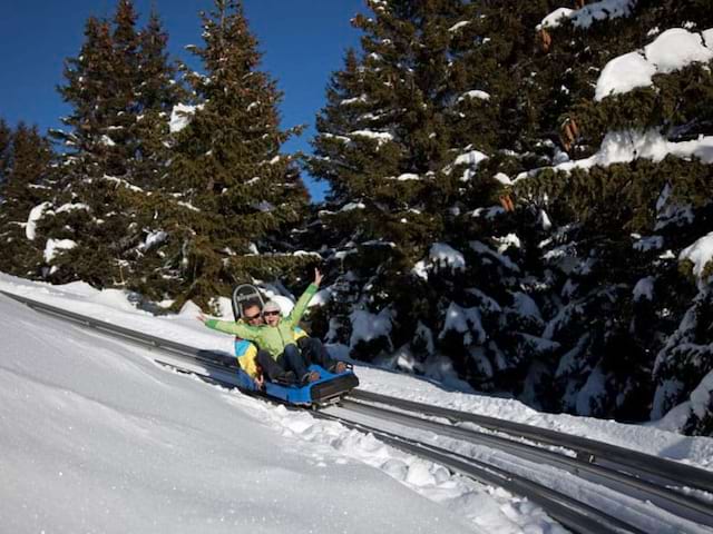 deux ados faisant de la luge en savoie en colonie de vacances d'hiver