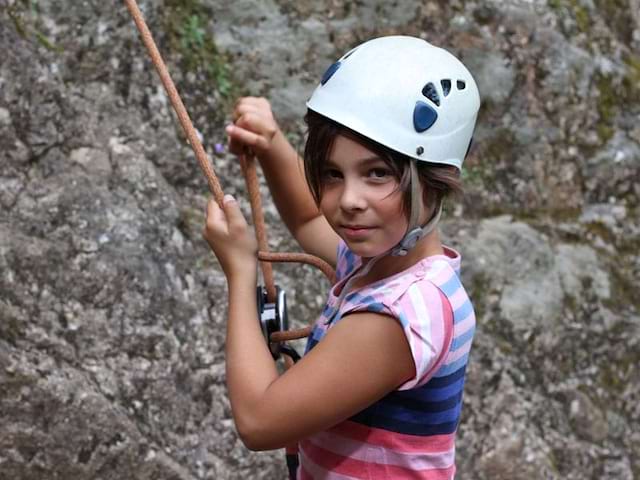 Portrait d'une fillette faisant de l'escalade en colo