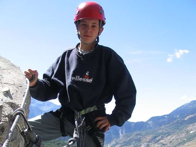 Jeune garçon qui profite de sa colo durant une activité escalade