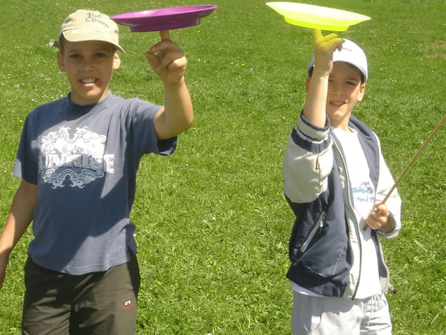 Enfants qui font tenir des assiettes en équilibre en colo de vacances Cirque à Retournac cet automne
