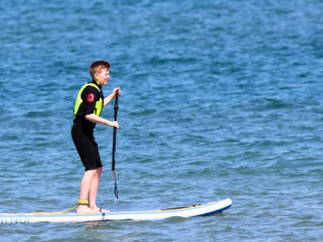Garcon qui fait du stand up paddle en colo de vacances cet automne