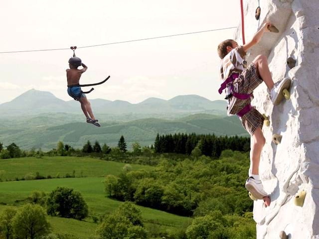 Enfants escaladant la roche en colonie de vacances