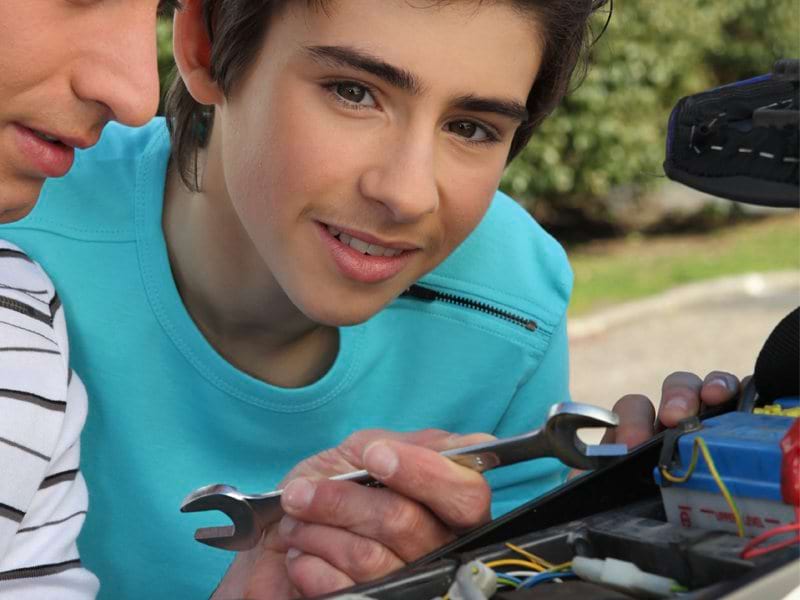 Préado apprenant la mécanique sur une moto