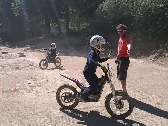 Enfant en train de faire de la moto sur un terrain aménagé