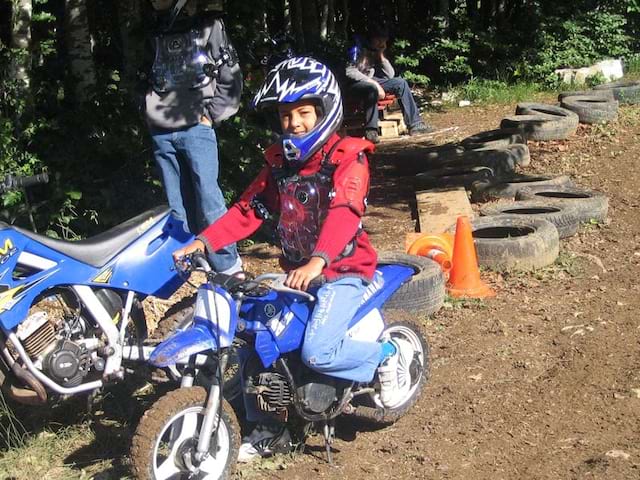 Garçon qui fait de la moto sur un terrain de motocross en colo