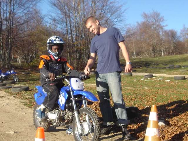 Enfant qui apprend à faire de la moto en colo