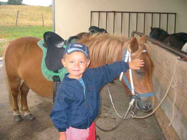 Enfant qui caresse un poney