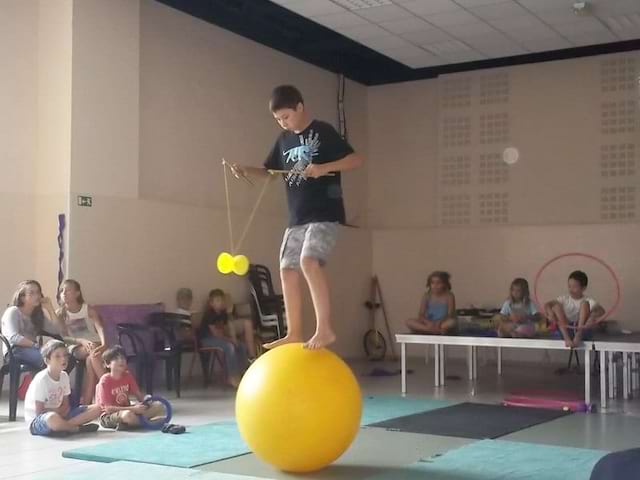 Enfant sur un ballon jonglant avec un diabolo