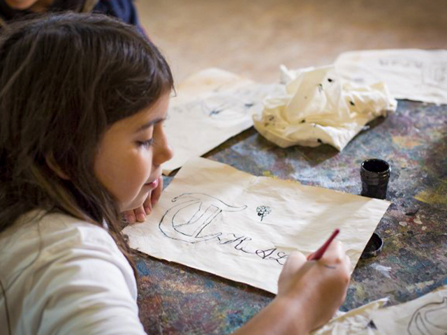 jeune qui apprend la calligraphie sur feuille