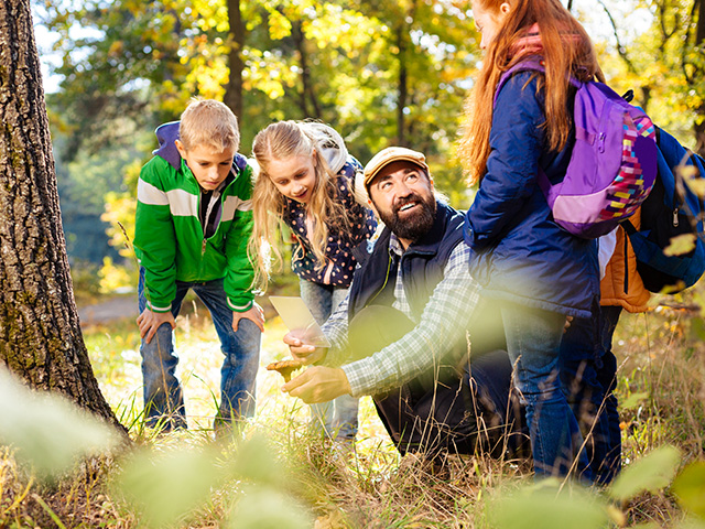Intervenant qui apprend aux élèves des secrets sur la nature en classe découvertes cet automne