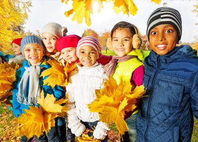 Enfants jouant avec les feuilles d'automne en colo