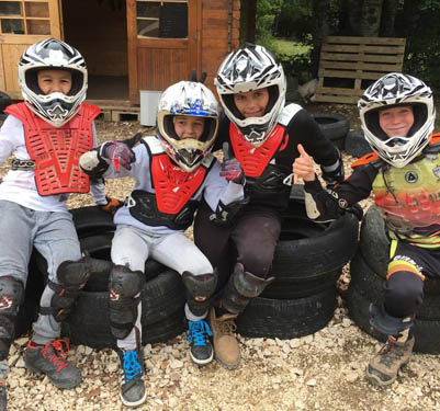 Groupe d'enfants conduisant une moto électrique en colonie de vacances
