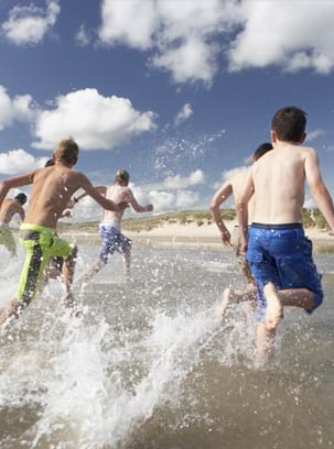 Groupe d'enfants qui courent au bord de la mer