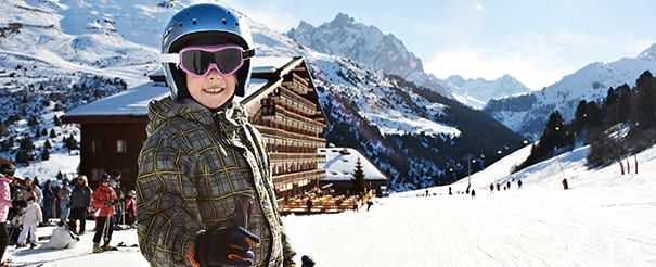 Enfant heureux en colonie de vacances au ski à Courchevel cet hiver