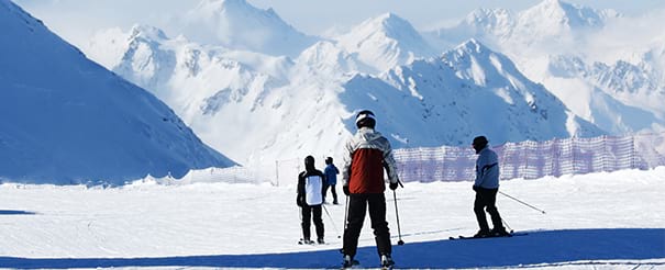 Groupe de jeunes admirant les montagnes en colonie de vacances ski cet hiver