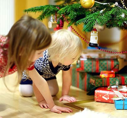 deux soeurs cherchant les cadeaux sous le sapin de noel