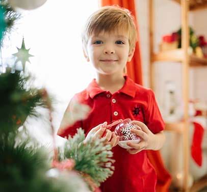 jeune garcon en train de preparer le sapin pour noel