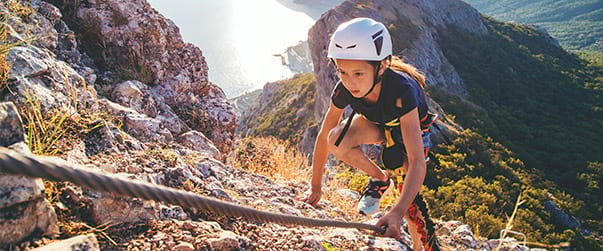 Fillette faisant de la via ferrata en colo cet automne