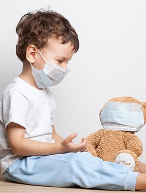 Enfant avec son nounours portant tous deux un masque de protection des virus