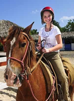 Jeune fille sur son cheval en colonie de vacances équitation à la toussaint