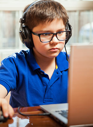 Enfant jouant aux jeux vidéos en colonie de vacances à la toussaint