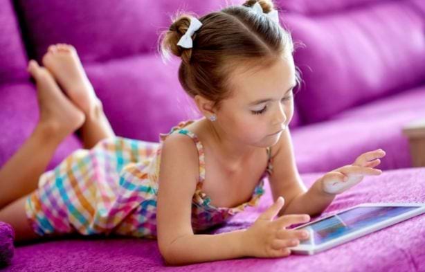 Fillette choisissant sa colo avec ses parents sur tablette