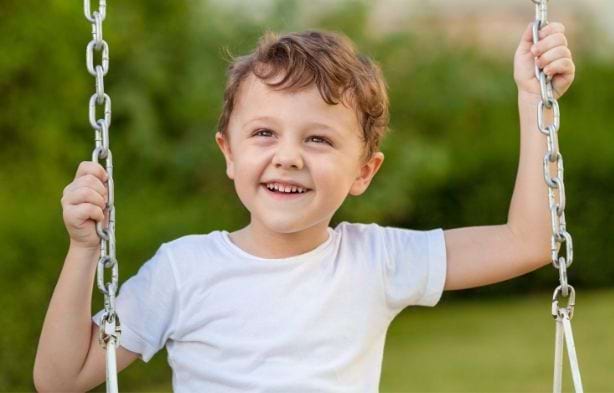 Jeune enfant en colo faisant de la balancoire