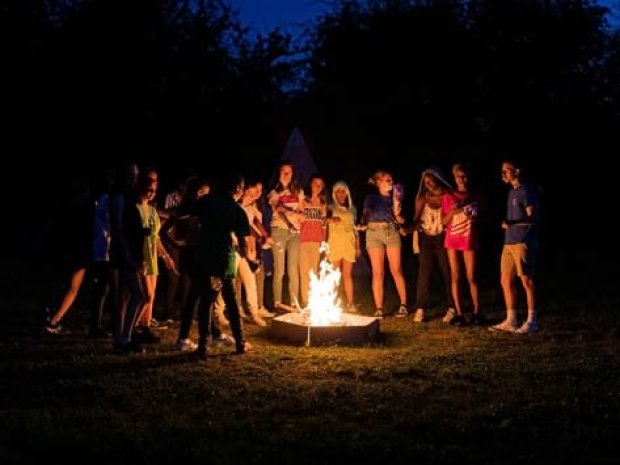 Enfants autour d'un feu de camps en colonie de vacances équestres