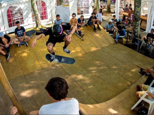 Groupe d'enfants et d'ados qui performent sur la rampe de skate park du centre de colonie de vacances
