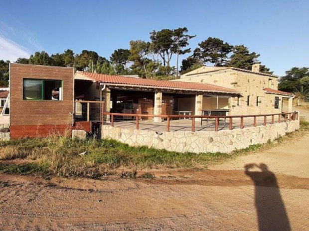 Hébergement collectif avec un mur de pierres au camping Tikiti à Propriano en Corse après les travaux lors d'une colo de vacances 