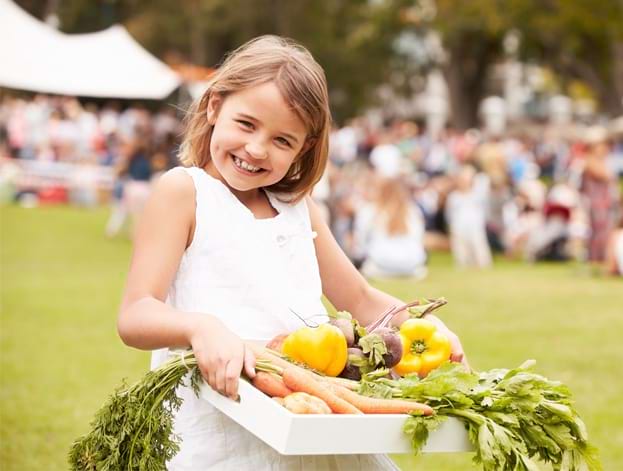 Jeune fille portant un panier de légumes bio