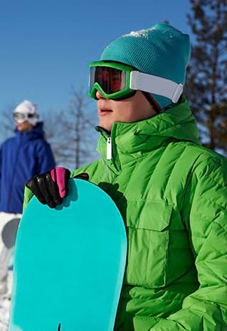 Enfant avec son matériel de snow en colonie de vacances d'hiver