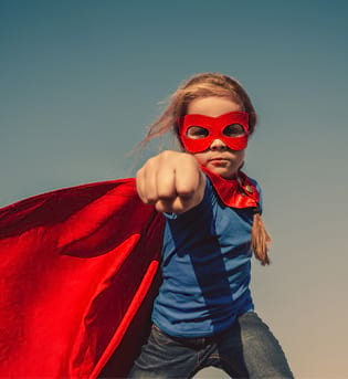 Jeune fille avec masque et cape de superheros