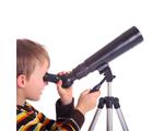 Petit garçon qui regarde dans un téléscope