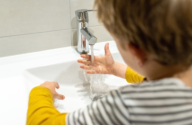 Jeune enfant qui se lave les mains tout seul