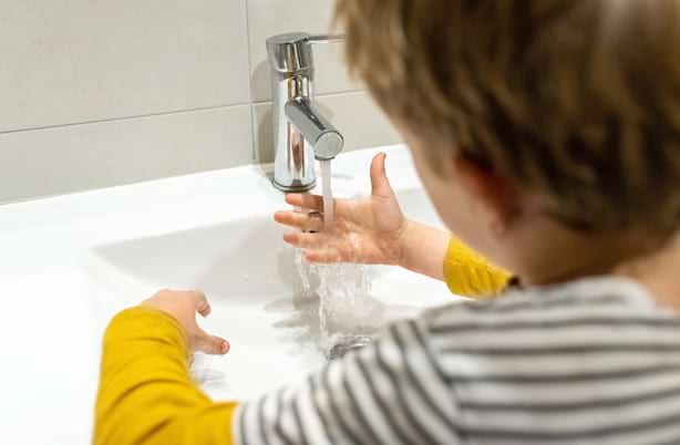 Jeune enfant qui se lave les mains tout seul