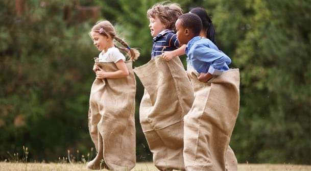 Enfants qui jouent à la course en sac 