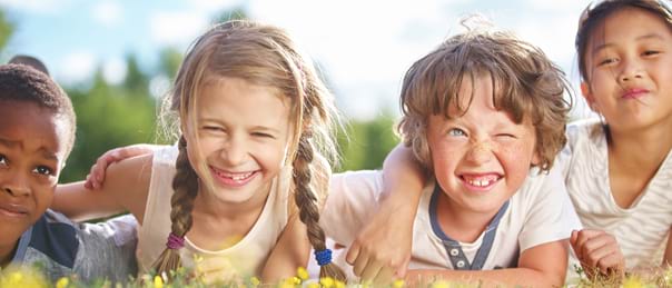 Enfants souriants qui s'amusent dans l'herbe