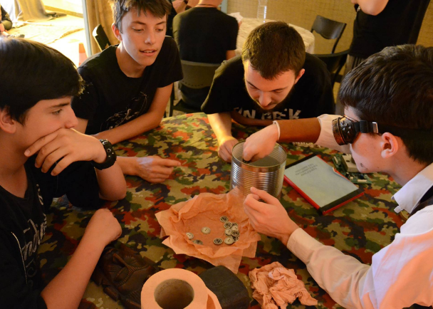 Ados et enfants jouant aux jeux de société en colonie de vacances cet été