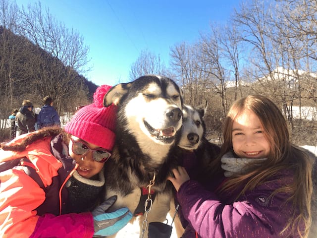 Deux jeunes filles en colo Duo Nordique qui profitent de leur activité chiens de traîneaux