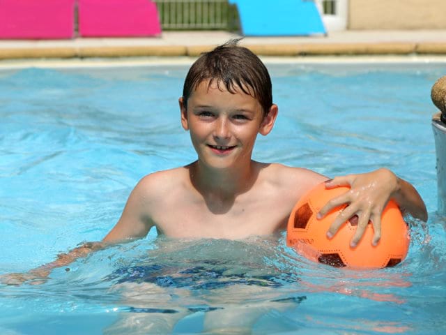 Jeune qui nage en colo de vacances multi activités et sportive cet été