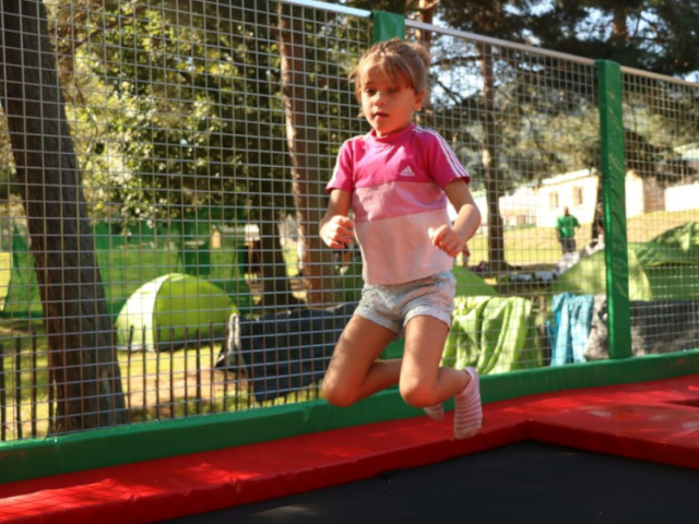 Jeune fille qui s'amuse sur un trampoline en colonie de vacances durant la Toussaint