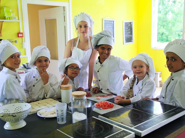 enfants apprenant à faire la cuisine en colonie de vacances
