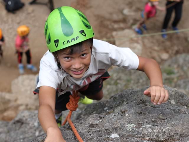 Enfant qui fait de l'escalade durant sa colo Défi Aventures ce printemps