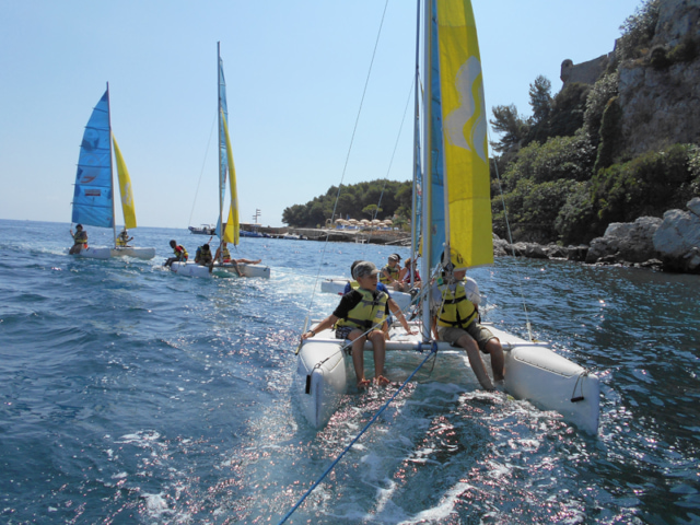 Enfants faisant de l'optimist en colonie de vacances à la mer