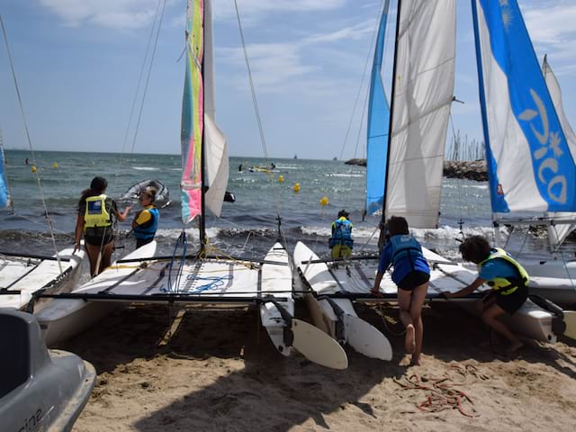 Enfants montant sur un bateau en colonie de vacances à la mer