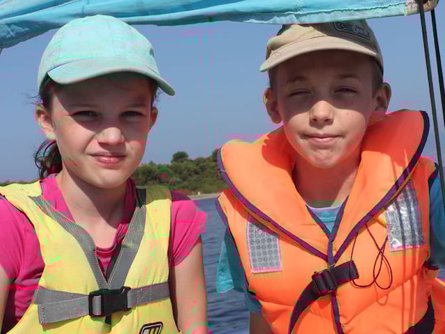 Portrait d'enfants portant un gilet de sauvetage en colo à la mer